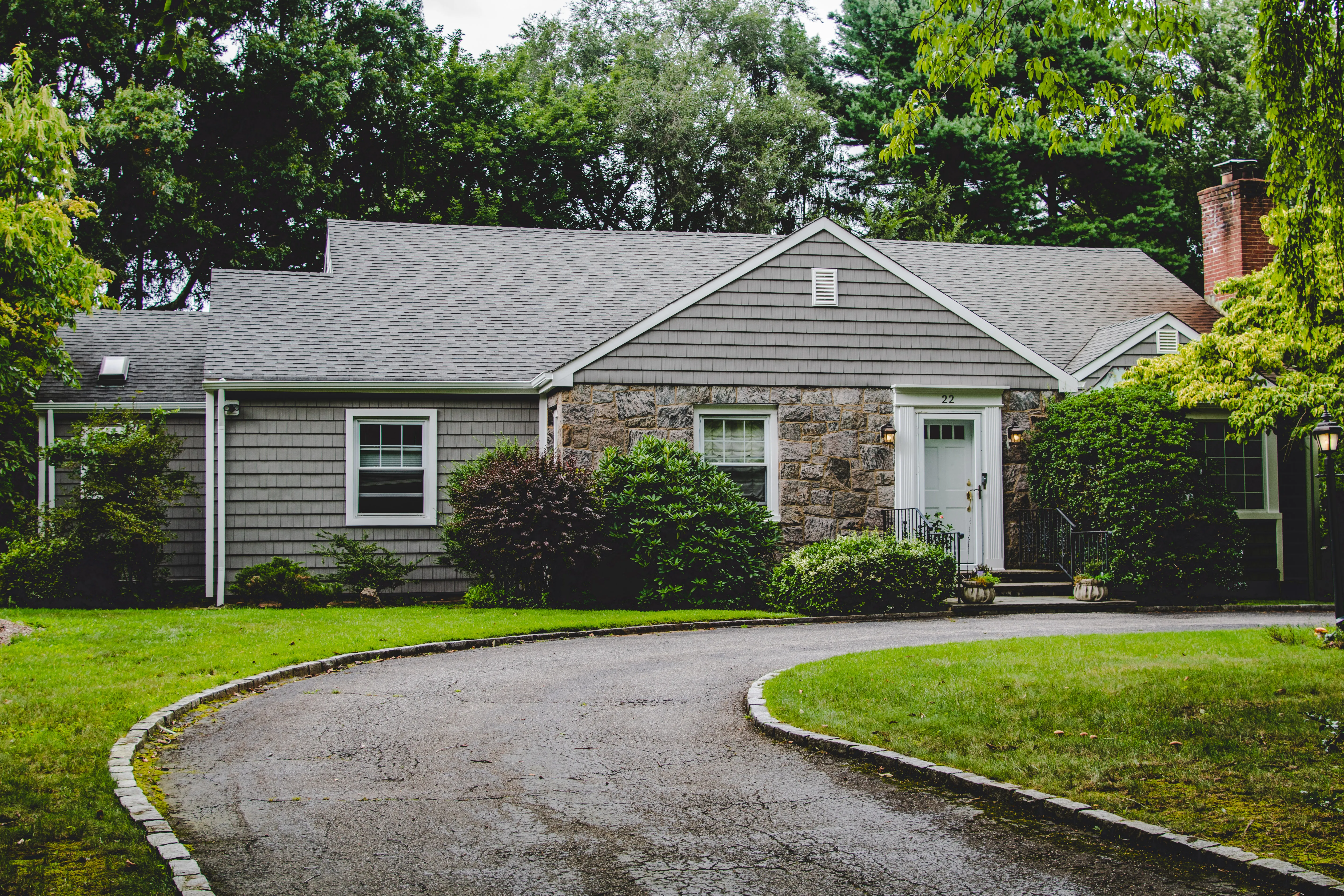 Ranch home with gray cedar shake-style siding and natural stone accent around the front door